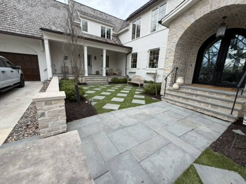 Mulched beds framing a stone walkway and entry
